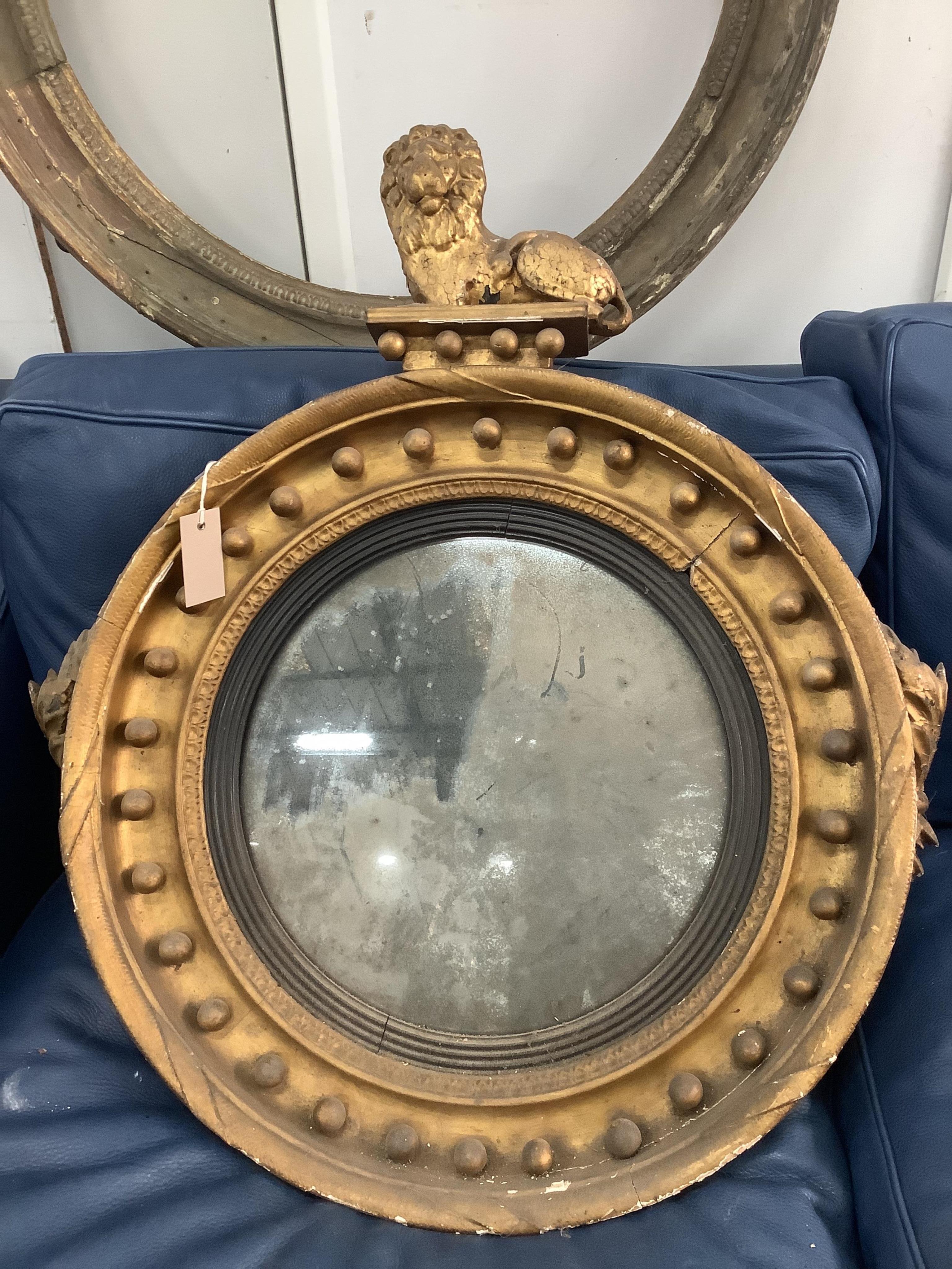 Two Regency circular convex wall mirrors, larger diameter 58cm together with two carved eagle surmounts. Condition - poor